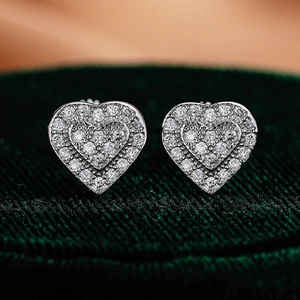 925 sterling silver heart-shaped moissanite stud earrings on green velvet jewelry box