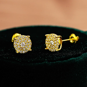 Macro shot of gold S925 sterling silver moissanite stud earrings on green velvet