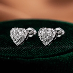 Macro detail of 925 sterling silver heart moissanite studs on green velvet display