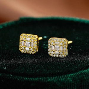 Square moissanite stud earrings in gold setting displayed on a green velvet box