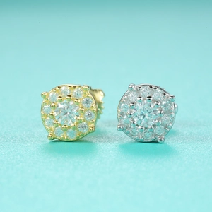 Macro shot of silver and gold moissanite stud earrings on a tiffany blue background