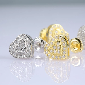 Macro shot of gold and silver heart moissanite stud earrings with secure screw-back