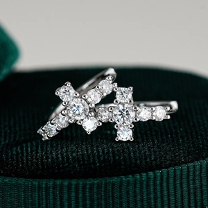 Détail de boucles d'oreilles croix en argent sterling serties de moissanites brillantes
