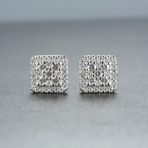 Macro shot of 925 sterling silver square moissanite stud earrings on a grey background