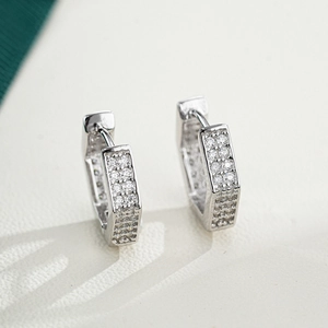 Macro shot of silver geometric hoop earrings with pavé set moissanite stones
