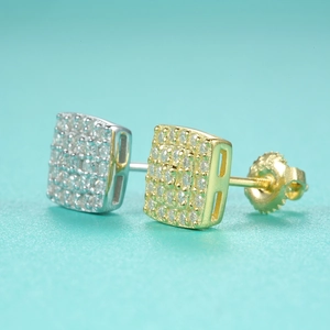 Macro shot of silver and gold square moissanite stud earrings with screw-back design