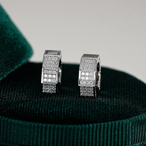 Détail macro de créoles en argent S925 avec moissanite pavée sur boîte en velours