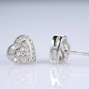 Macro detail of heart-shaped 925 silver stud earrings with moissanite pave setting
