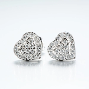 Macro detail of 925 sterling silver heart stud earrings with shimmering moissanite stones