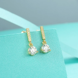 Macro view of gold S925 sterling silver moissanite drop earrings with tassel detail