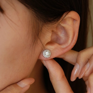 Orecchini a perno tondi in moissanite con doppio alone in argento su modella