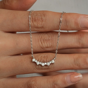 Elegant S925 sterling silver necklace with seven-stone moissanite arc pendant on hand