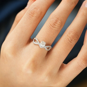 Elegant S925 silver infinity ring featuring a round moissanite center and pave band