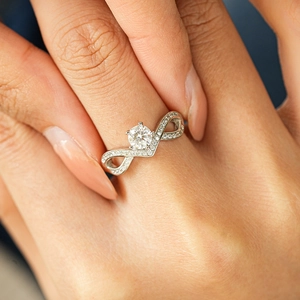 S925 silver infinity ring with round moissanite in a crown setting on a woman's hand