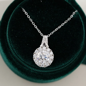 Macro shot of 2ct moissanite pendant on a green velvet box with sparkling diamond halo