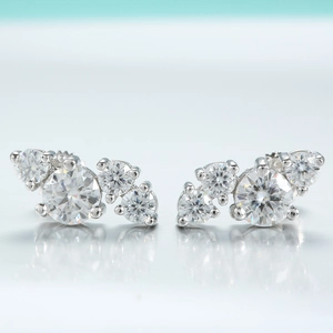 Gros plan de boucles d'oreilles en argent 925 et moissanite avec design courbe à quatre pierres