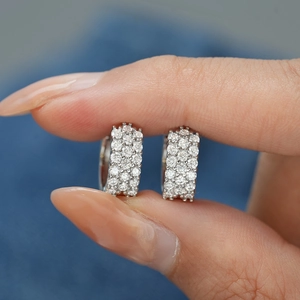 Gros plan sur des créoles en argent 925 avec serti pavé de moissanite à trois rangs
