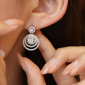 Gros plan d'une boucle d'oreille moissanite en argent 925 portée par un mannequin femme