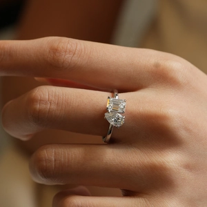 Detailed close-up of S925 silver ring featuring pear and emerald cut moissanite stones