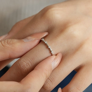 Détail d'une bague en argent S925 avec petits diamants ronds portée au doigt