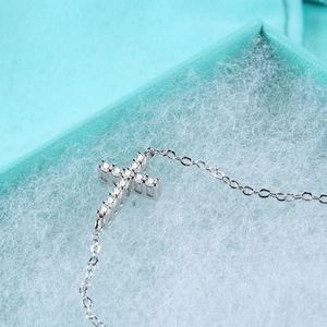 S925 sterling silver cross bracelet featuring D color Moissanite stones on a blue gift box