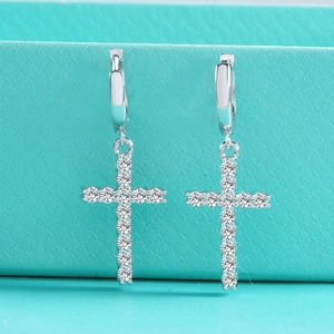 Macro shot of S925 sterling silver hoop earrings with shimmering cross-shaped moissanite pendants