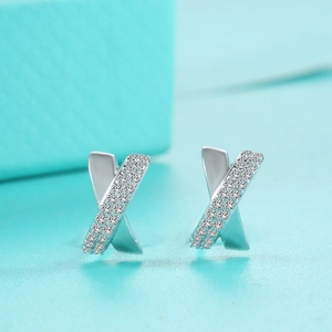 Macro detail of S925 silver criss-cross earrings with pavé-set moissanite stones