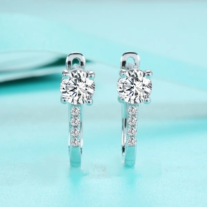 Macro detail of classic U-shaped S925 silver earrings featuring 1ct Moissanite diamonds