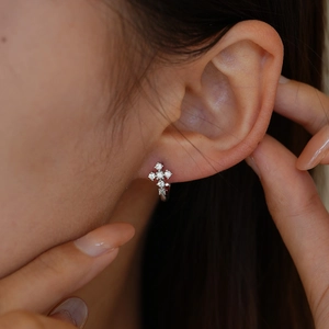 Boucles d'oreilles créoles croix en argent avec moissanite sur modèle au style élégant