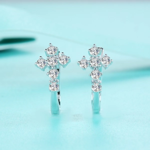 Vue macro de boucles d'oreilles croix en argent avec pierres de moissanite brillantes