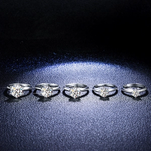 Macro shot of five six-prong moissanite rings in varying carat sizes on leather