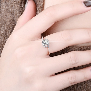 Close-up of 1 carat moissanite ring with halo setting and twisted pave band on hand
