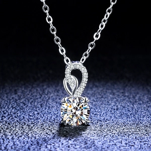 Macro shot of 1 carat moissanite pendant with silver chain and diamond-set bail detail