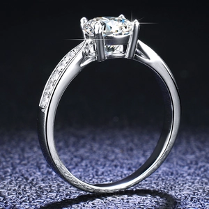 Side view of 1ct round moissanite ring with four-prong setting and side stone accents