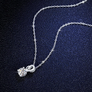 Detail of s925 silver necklace with infinity pendant and 1 carat moissanite gemstone