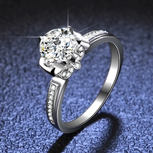 Moissanite ring with six-prong petal setting and sparkling side stones on blue texture