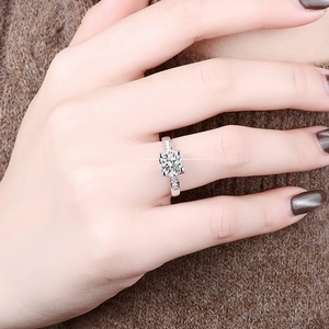 Gros plan d'une bague de fiançailles en argent S925 et moissanite à la main