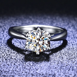 Macro view of classic six-prong setting Moissanite ring on a deep textured background