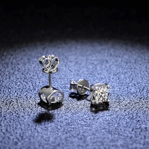 Macro shot of 925 silver moissanite earrings with crown prong setting on black background