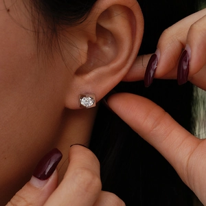 S925 sterling silver heart-shaped moissanite stud earring on ear with minimalist design