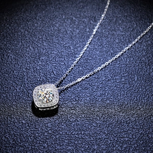 Close-up of 1 carat moissanite halo pendant with square-set stones on a fine silver chain