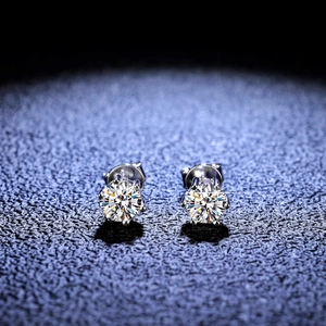 Macro shot of six-prong moissanite stud earrings on leather with professional lighting