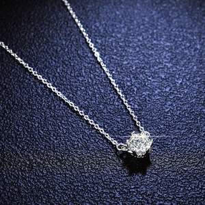 Macro shot of a 1 carat round moissanite snowflake pendant on a silver box chain
