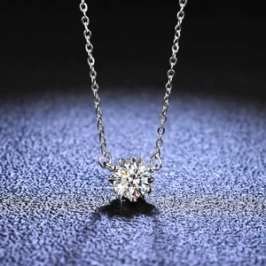 Macro shot of 1-carat moissanite snowflake pendant necklace on dark blue background