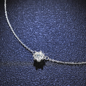 Macro shot of 1 carat round moissanite pendant with classic six-prong silver chain setting
