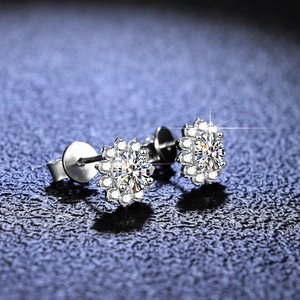 Macro view of sunflower halo earrings with moissanite center stone on blue leather