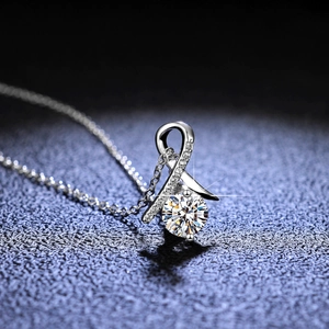 Macro shot of S925 sterling silver ribbon pendant with round moissanite and pave stones