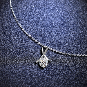 Macro detail of S925 silver pendant with moissanite center stone and side pavé setting