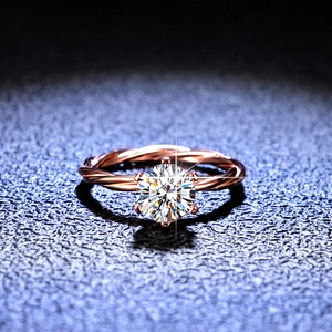 Moissanite rose gold ring featuring a twisted vine band and six-prong round cut stone