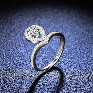 Anello a corona con moissanite e halo a goccia su sfondo blu scuro scintillante